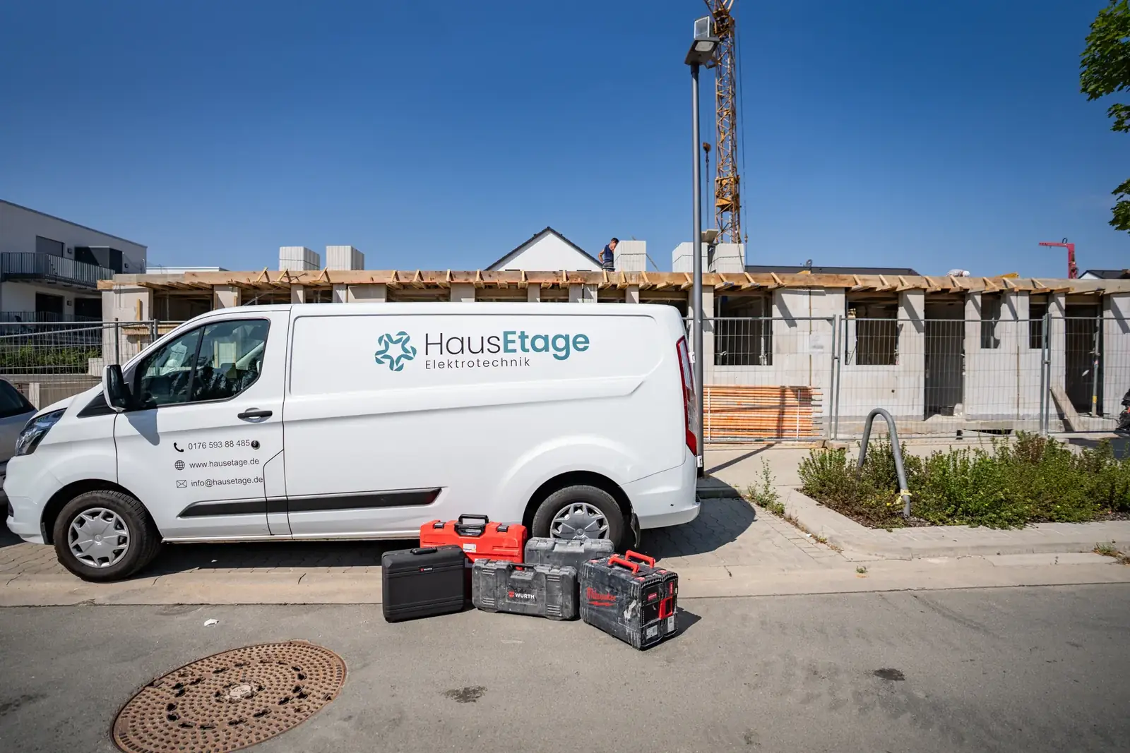 Servicefahrzeug von HausEtage Elektrotechnik mit Werkzeugkoffern vor einer Baustelle