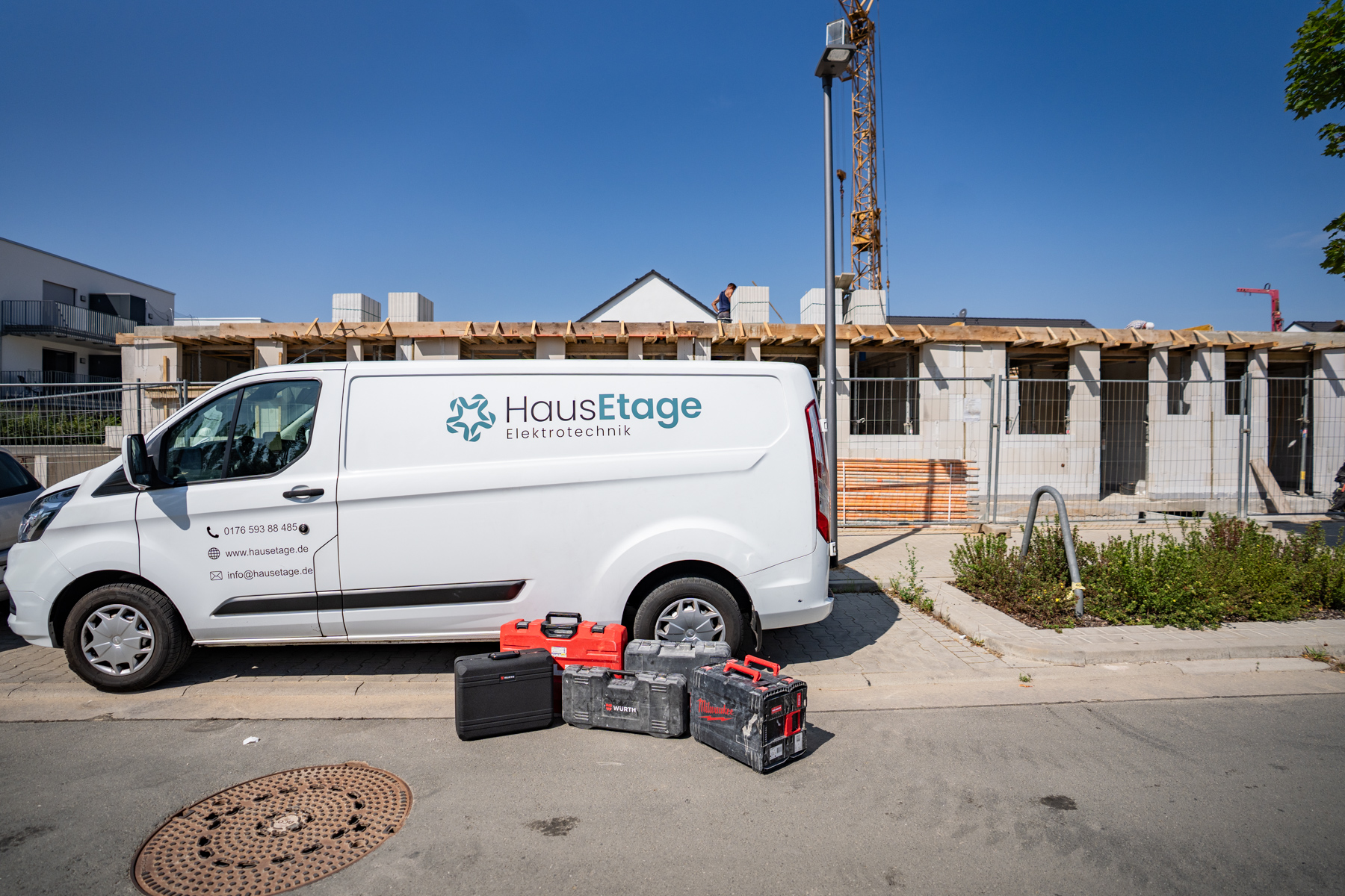 Servicefahrzeug von HausEtage Elektrotechnik mit Werkzeugkoffern vor einer Baustelle